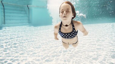 Family World Maedchen taucht im Thermalwasser Aussenbecken | © Alpentherme Gastein/Marktl Photography