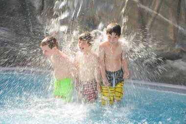 Family World Kleinkinder Aussenbecken KInder spielen am Wasserfall | © Alpentherme Gastein/Wolkersdorfer