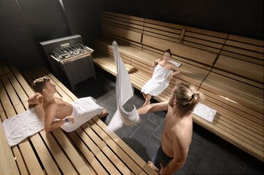 Sauna World Paar entspannt in Stollensauna Saunameister wachelt | © Alpentherme Gastein/Marktl Photography