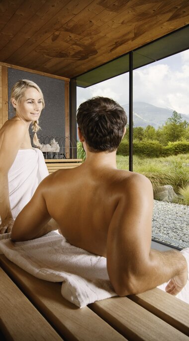 Sauna World Paar in Kristall Sauna mit Blick auf Thermalwasser Badesee | © Alpentherme Gastein/Marktl Photography
