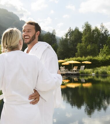 Paar lachend am Steg beim Kristall See in der Sauna World | © Alpentherme/Marktl